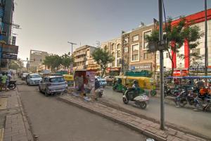 una strada trafficata della città con auto e persone in moto di Hotel DHD - PAHARGANJ a Nuova Delhi