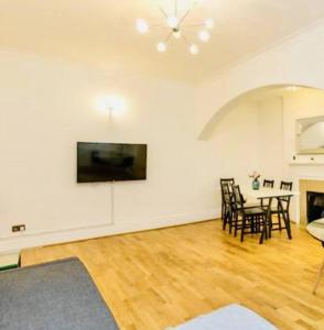 uma sala de estar com mesa e cadeiras em 2 Bedroom flat in diplomatic enclave in Kensington em Londres