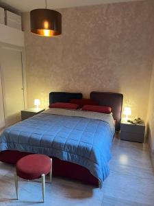 a bedroom with a bed with a blue comforter and a red chair at Wave Home 2 in Castel Gandolfo