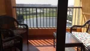 een balkon met stoelen en uitzicht op een waterlichaam bij Two Bedroom Apartment at Golf Porto Marina in El Alamein