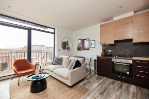 een woonkamer met een bank, een tafel en een keuken bij The Wembley Crib - Lovely 1BDR Flat with Balcony in Londen