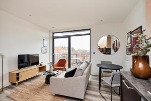 een woonkamer met een bank en een tv bij The Wembley Crib - Lovely 1BDR Flat with Balcony in Londen