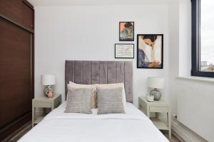 een slaapkamer met een bed met 2 tafels en 2 lampen bij The Wembley Crib - Lovely 1BDR Flat with Balcony in Londen