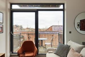 een woonkamer met een glazen schuifdeur en een tafel bij The Wembley Crib - Lovely 1BDR Flat with Balcony in Londen
