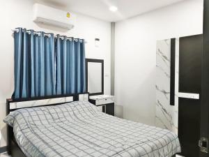 a bedroom with a bed and a blue curtain at The Engineer's Villas, Krabi in Ban Khlong Chi Lat