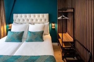 ein Schlafzimmer mit einem großen Bett mit blauen Wänden in der Unterkunft Jupiter Hotel in Amsterdam