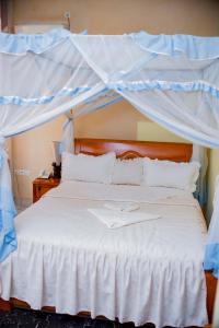 - une chambre avec un lit blanc à baldaquin dans l'établissement Tigers's apartment Hotel, à Bujumbura