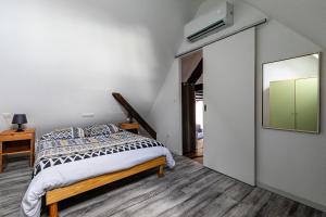 1 dormitorio con cama y espejo en Le Chêne - Appt au calme pour 5, en Quatzenheim