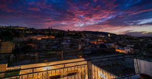 een balkon met uitzicht op de stad bij zonsondergang bij Riad Fez Qamar in Fès