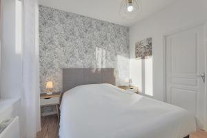 1 dormitorio con cama blanca y ventana en Escarpelle - Moderne appartement pour 4, en Lens