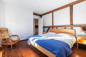 ein Schlafzimmer mit einem großen Bett und einem Stuhl in der Unterkunft Le Houblon - Appt refait à neuf au calme in Quatzenheim