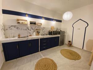 een keuken met blauwe kasten en een aanrecht bij Beautiful Apartment with Private Rooftop Terrace in Tanger
