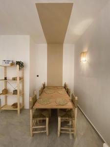 een eetkamer met een houten tafel en stoelen bij Beautiful Apartment with Private Rooftop Terrace in Tanger