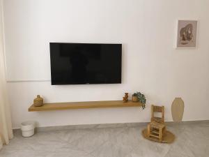 een flatscreen-tv aan een witte muur bij Beautiful Apartment with Private Rooftop Terrace in Tanger