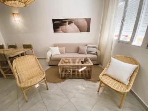 een woonkamer met een bank, stoelen en een tafel bij Beautiful Apartment with Private Rooftop Terrace in Tanger