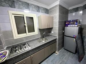 Elle comprend une petite cuisine équipée d'un évier et d'un réfrigérateur. dans l'établissement شقة فندقية بالمعادى 116, au Caire