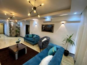 - un salon avec un canapé bleu et une table dans l'établissement شقة فندقية بالمعادى 116, au Caire