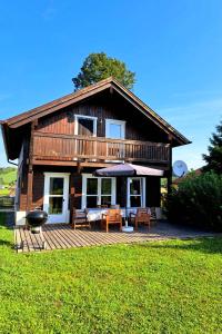 una casa con terrazza con sedie e griglia di Gemütliches Holzhaus in Gamlitz! a Gamlitz