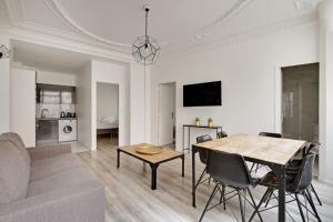 a living room with a table and a couch at Cosy apartment-6P-PigalleLafayette in Paris