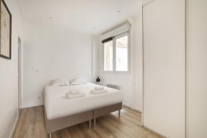a white bedroom with a bed and a mirror at Cosy apartment-6P-PigalleLafayette in Paris