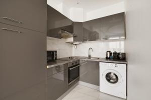 a kitchen with a washing machine and a washer at Cosy apartment-6P-PigalleLafayette in Paris