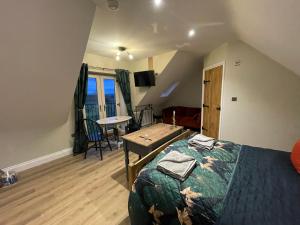 a bedroom with a bed and a table in a room at Roseberry Barn, Bullamoor, Northallerton, North Yorkshire in Brompton