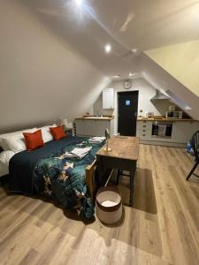 a bedroom with a bed and a table and a kitchen at Roseberry Barn, Bullamoor, Northallerton, North Yorkshire in Brompton