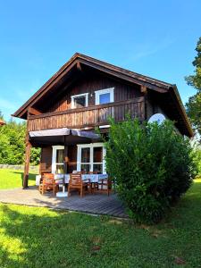 una baita di tronchi con tavolo e sedie su una terrazza di Gemütliches Holzhaus in Gamlitz! a Gamlitz