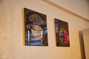 two pictures of a coffee cup on a wall at DeLuxe Ap Almaty Центр in Almaty