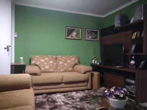 a living room with a couch and a flat screen tv at Casa em Pomerode_SC in Pomerode
