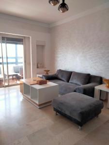 ein Wohnzimmer mit einem Sofa und einem Couchtisch in der Unterkunft Appart vacances marina in Agadir