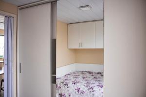 um pequeno quarto com uma cama num armário em Otimo apto 9 min do aeroporto em Florianopolis SC em Florianópolis