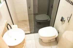 uma casa de banho com um WC, um lavatório e um chuveiro em Otimo apto 9 min do aeroporto em Florianopolis SC em Florianópolis