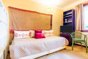 um quarto com uma cama com almofadas cor-de-rosa em Maison de 3 chambres avec jardin clos et wifi a Ceret em Céret