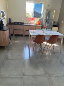 uma cozinha com uma mesa branca e 2 cadeiras em Residencial Valentina Jurere em Florianópolis