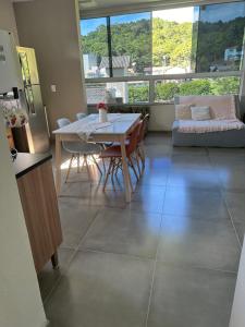 eine Küche und ein Esszimmer mit einem Tisch und Stühlen in der Unterkunft Residencial Valentina Jurere in Florianópolis