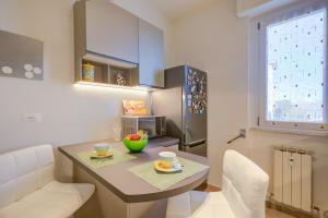 - une petite cuisine avec une table et des chaises dans la chambre dans l'établissement Alelù Classy And Chic Apartment - Happy Rentals, à Stresa