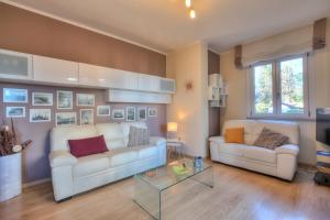- un salon avec deux canapés blancs et une table dans l'établissement Alelù Classy And Chic Apartment - Happy Rentals, à Stresa