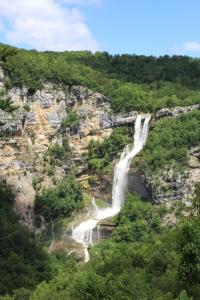 uma cascata no lado de uma montanha em Le pied-à-terre du botaniste em Hauteville-Lompnes