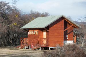 a small wooden cabin with a metal roof at Glamping Río Serrano - Caja Los Andes in Puerto Natales