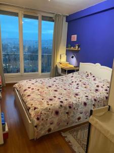 1 dormitorio con 1 cama con pared morada en Appartement entier 3 pieces., en Argenteuil