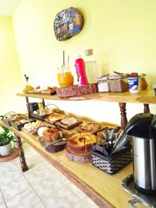 a shelf filled with different types of bread and pastries at Pousada dos Ventos São Lourenço in São Lourenço