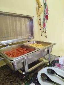 two trays of food sitting on a counter at Pousada dos Ventos São Lourenço in São Lourenço