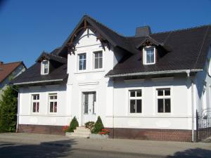 uma grande casa branca com um telhado preto em Ferienwohnung Zöllner em Burg