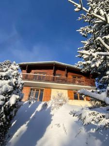 een huis in de sneeuw met sneeuw bedekte bomen bij Chalet Vue Panoramique in Bolquere Pyrenees 2000