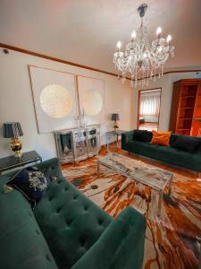 馬尼拉的住宿－Spacious Luxury 3BR at the Heart of Makati，客厅配有绿色沙发和吊灯。