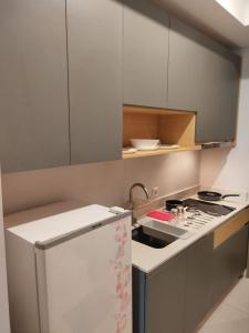 uma cozinha com um lavatório e um fogão forno superior em Miky Studio em Jakarta