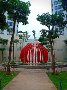 eine große rote Skulptur in einem Park mit Bäumen in der Unterkunft Miky Studio in Jakarta