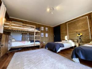 1 dormitorio con 2 literas y paredes de madera en Chalet Vue Panoramique en Bolquere Pyrenees 2000