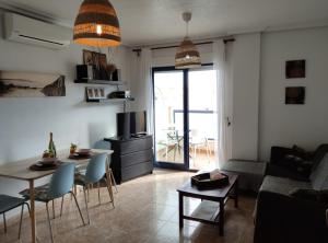 a living room with a table and a couch at Apartamento MANDARÍN Playamarina II in Playas de Orihuela